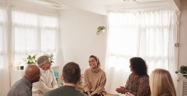 Woman Speaking At Support Group Meeting For Mental Health Or Dependency Issues In Community Space